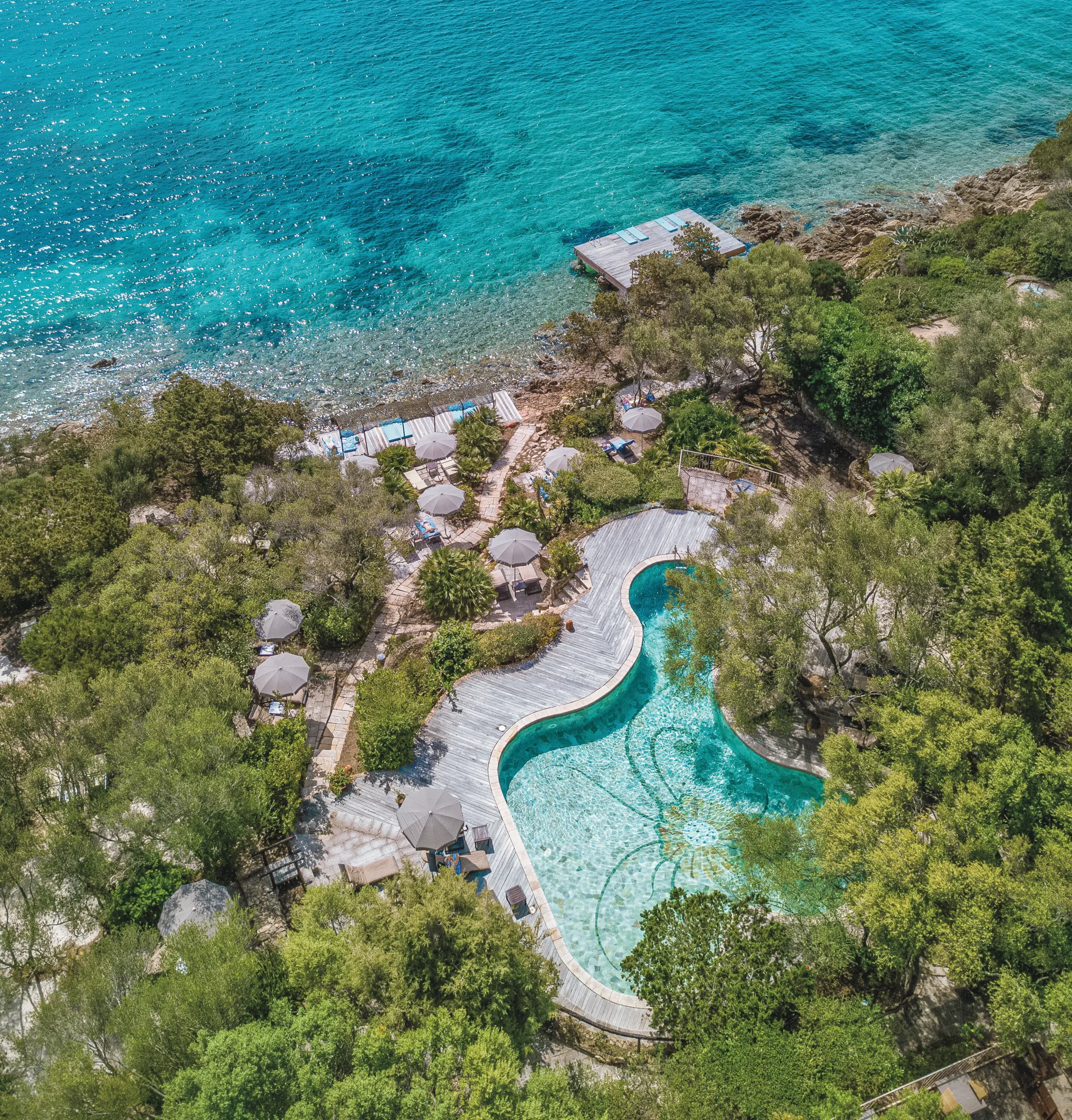 Vue des piscines extérieures à l’eau de mer chauffée de l'Hôtel Capo d’Orso Thalasso & SPA en Sardaigne, offrant des moments inoubliables avec ses plages turquoises, restaurants variés, et centre de thalassothérapie. Un lieu parfait pour couples recherchant luxe, détente, et harmonie avec la nature.