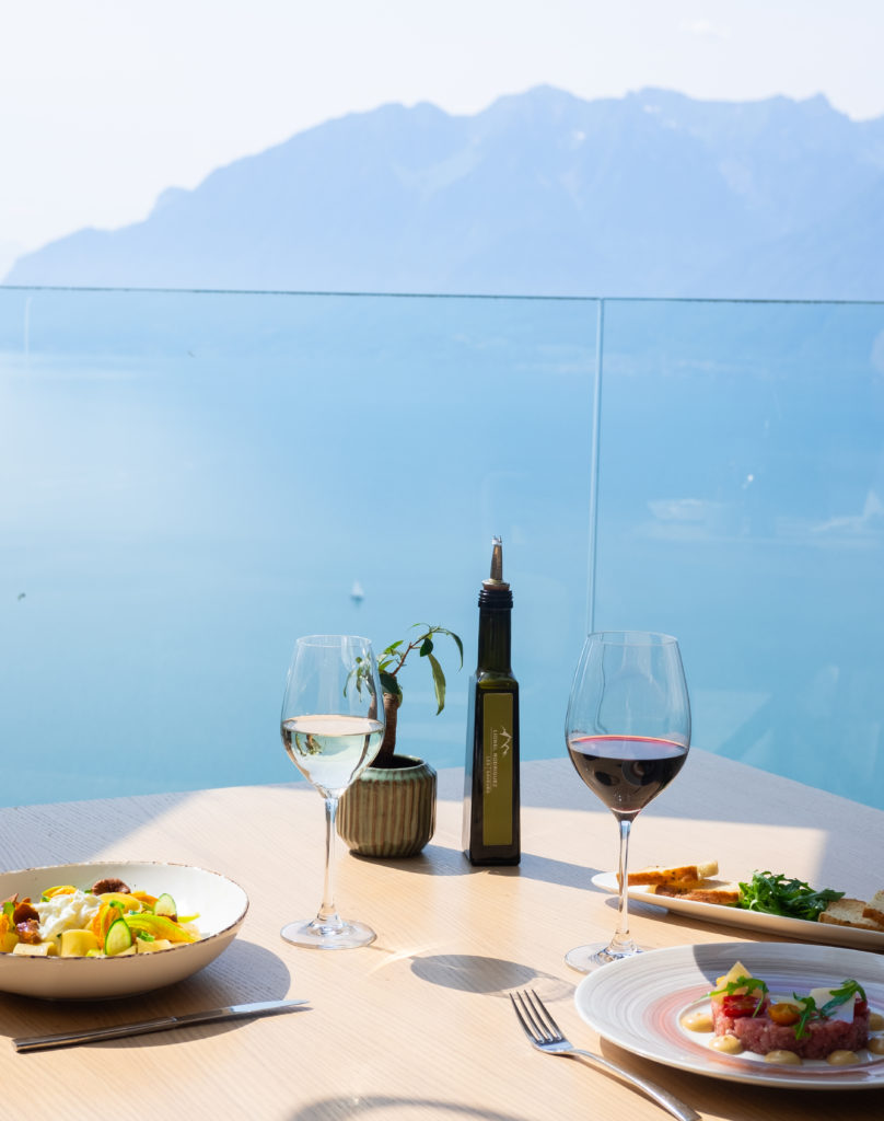 Iconique et incontournable, le Deck offre une des plus belles vues de la région, entouré de vignes et surplombant le lac Léman, avec une carte raffinée recommandée par le Guide Michelin. Terrasses été 2024