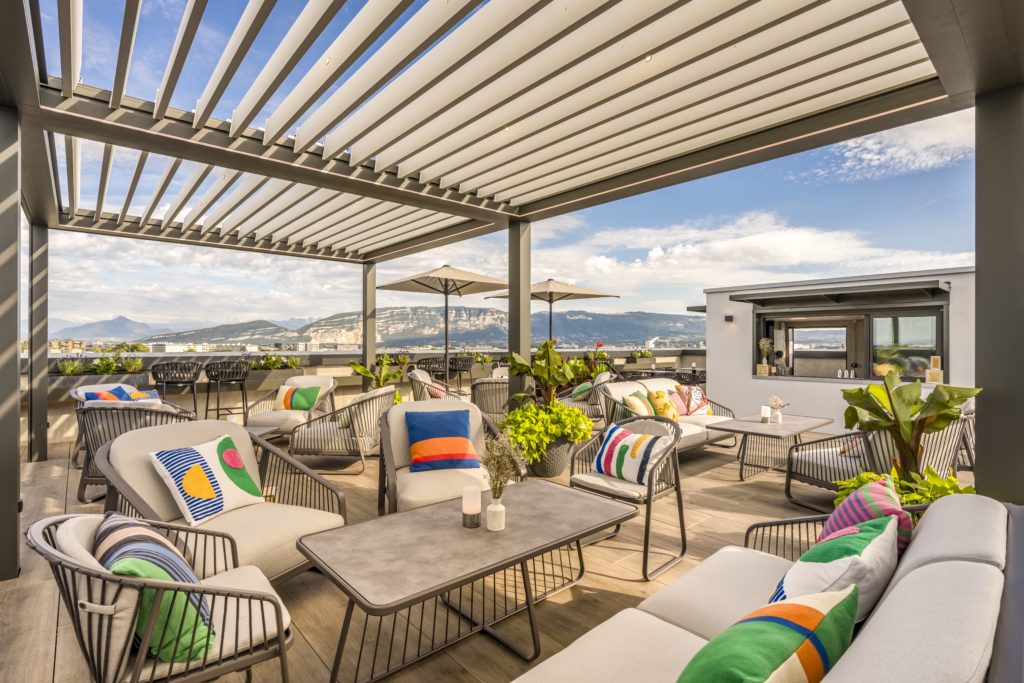 La terrasse élégante de la Suite 1201, au 12ème étage du Geneva Marriott Hotel, offre une vue panoramique sur les montagnes et des cocktails savoureux préparés par des barmans talentueux.